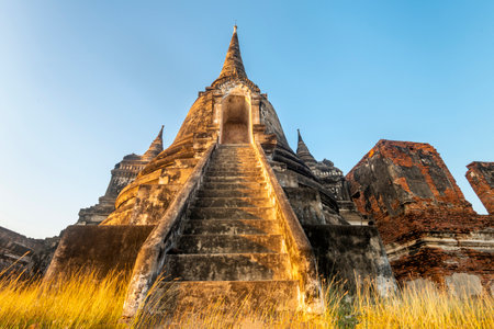Low angle view,looking up to the doorway into an ancient pagoda,reflecting the last rays of the sun as it sets,at the holy historic site of the former Siamese capital.の写真素材