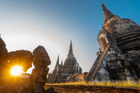 Part of the extensive temple grounds and important historic site,with many ancient Buddhist pagodas,with surrounding brickwork,stood amongst trees,bathed in the warm light of the setting sun.の写真素材