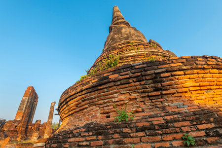 Part of the extensive temple grounds and important historic site,with many ancient Buddhist pagodas,with surrounding brickwork,bathed in the warm light of the setting sun.の写真素材