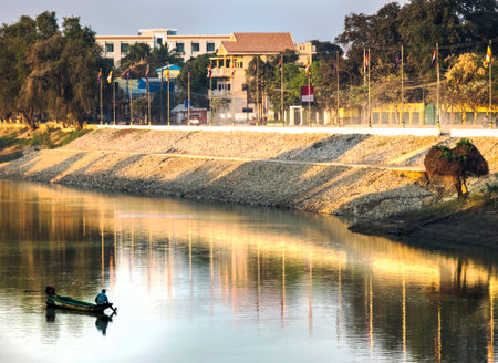 Battambang Province,Cambodia-Feb 26 2024:In the city center along the main river, a fisherman tries his luck,putting out a net to catch fish at sunset.の写真素材