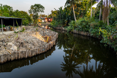 A winding waterway,part of an intricate network of small connecting canals and pathways,runs past resident's small wooden houses, through lush vegetation,bio-diverse natural habitats and farmland.の写真素材