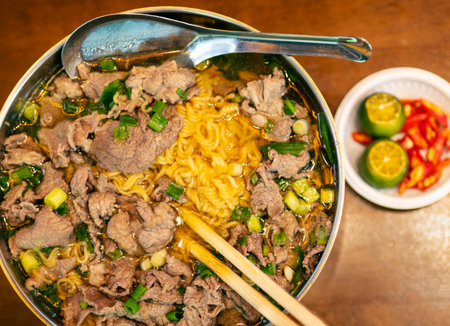 Traditional cuisine of Vietnam,served in a metal bowl and soup spoon ,with fresh green spring...