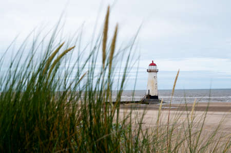 Talacre lighthouse, North Wales shot at dusk with motion blur dune grass in the foreground.  copy space available top right corner of imageの写真素材