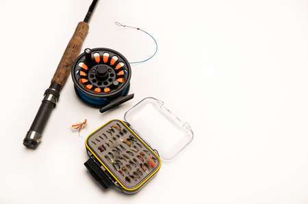 Fly fishing rod, reel, and flies on a white background with copy space