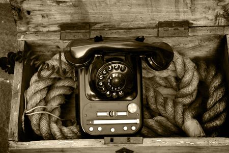 Sepia photo of phone in a wooden box of rope on sale on the market stall of the Braderie, Lille, France, 2007の写真素材