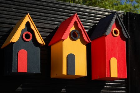 Three wooden bird boxes lined up on black backgroundの写真素材