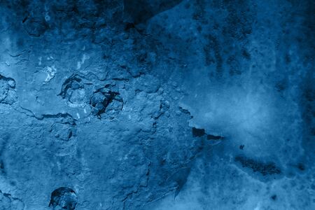 Light casting shadow over dark blue cracked rust backgroundの写真素材