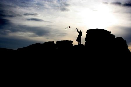 Girl flying kite on rocks, Dartmoor, Englandの写真素材