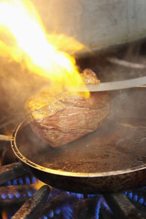 steaks cooking on stoveの写真素材