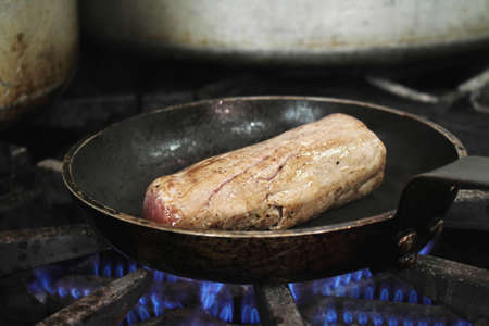 steaks cooking on stoveの写真素材