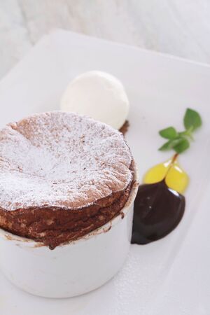 chocolate souffle plated dessert with clotted creamの写真素材