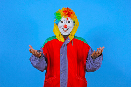 Clown in a red jacket on a blue background. Studio photoの写真素材