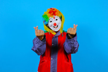 Clown in a red jacket on a blue background. Studio shotの写真素材