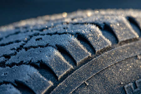 Car tire in winter on an icy roadの写真素材