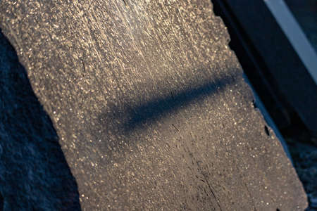 long shadow on granite slate or slab in frosty morning golden sunlight