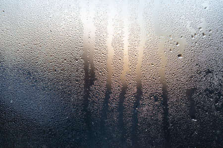 dew on window glass. Morning sunrise light