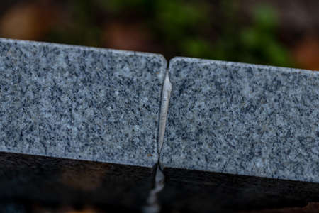 two pieces of gray polished granite sticked together with white glueの写真素材