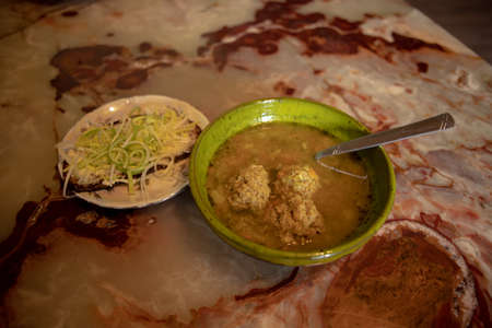 soup with meatballs and dark bread with chopped leeks