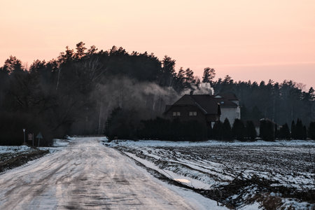 Country road in the winter at sunset. Rural landscape with a country houseの写真素材