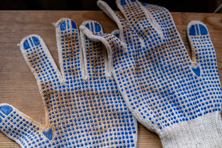 Dirty work gloves on a wooden background. Close-up.