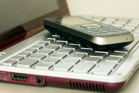 virtual banking concept - mobile phone over laptop keyboardの写真素材