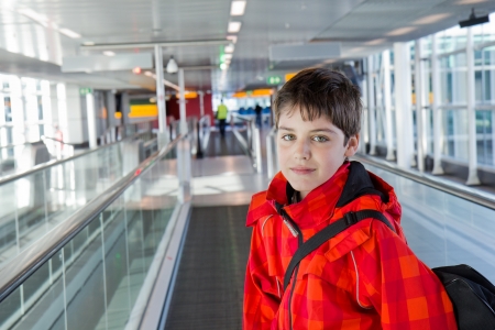 boy in modern airport hall looking straitの写真素材