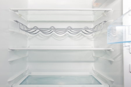 empty white  open fridge with some shelvesの写真素材