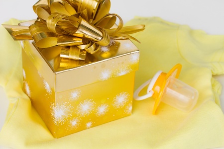 yellow baby clothes with  golden gift box