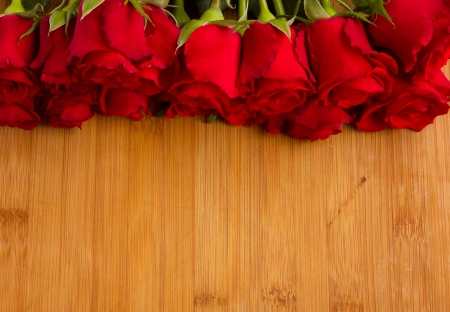 red roses buds border on wooden background の写真素材