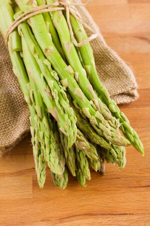 fresh green asparagus sprouts  laying on wooden tableの写真素材