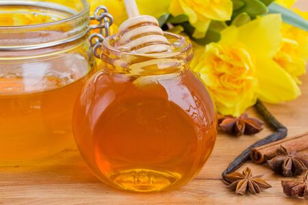glass jar of floral honey   on wooden tableの写真素材