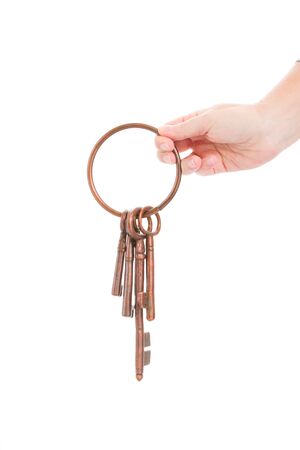 hand holding antique ring of keys isolated on white backgroundの写真素材