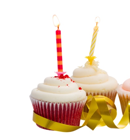 Two cupcakes  with burning candles isolated on white backgroundの写真素材