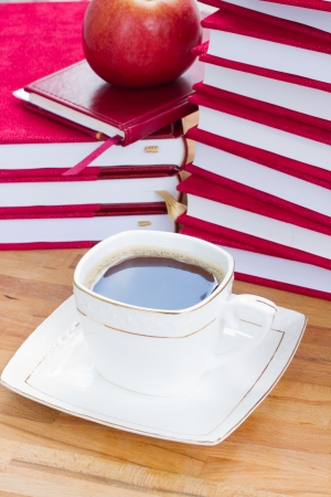 coffee break in library with cup of black coffee on table, apple  and  booksの写真素材