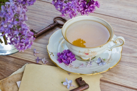 summer cup of tea with lilac  and vintage photosの写真素材