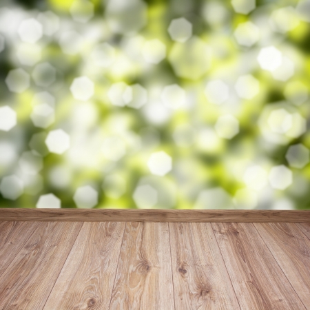 empty wooden planks with green leaves bokeh backgroundの写真素材