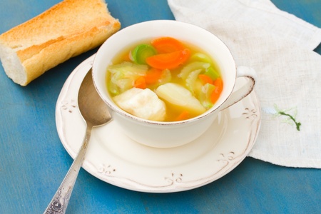 Fish soup with silver spoon on blue wooden tableの写真素材