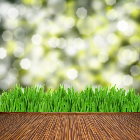 empty wooden planks with green grass and leaves bokeh backgroundの写真素材
