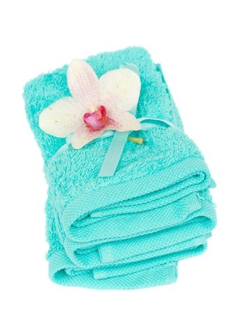 pile of bath towels with orchid flower isolated on white backgroundの写真素材
