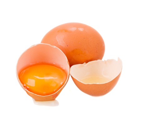 whole and broken raw eggs isolated on whiteの写真素材