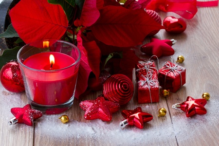christmas red burning candle  with  decorations on wooden tableの写真素材