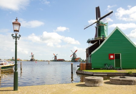 dutch windmills over river in Zaanse Schans in sunny day, Netherlandsの写真素材