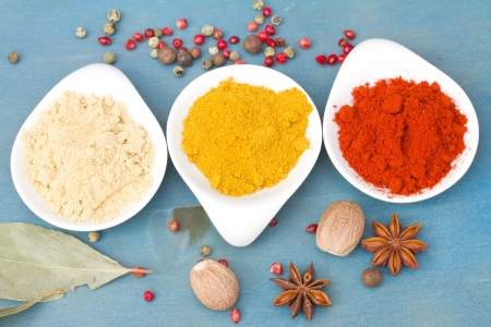 colorful mix of spices of  cucrma, red pepper and  ginger with seeds of anise  on  blue wooden tableの写真素材