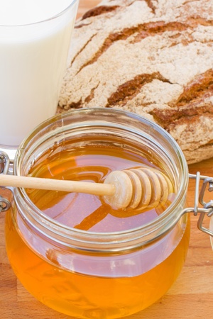 dripping honey and wooden stick close upの写真素材