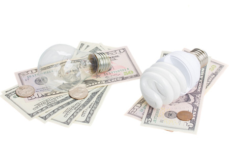 energy saving and normal  lamp bulbs on dollars money  isolatd on whiteの写真素材
