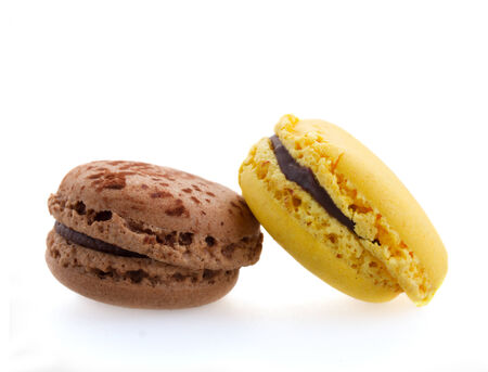 two  french macaroons yellow and brown  isolated on white backgroundの写真素材