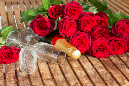 Valentine's day dark red roses and neck of champagne wine isolated on whiteの写真素材