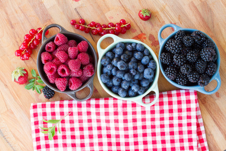 three bowls of fresh berries  on wooden tableの写真素材