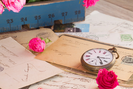 old pile of mail  and antique clock  on wooden table