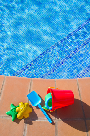 bucket with plastic beach toys pool  blue waterの写真素材